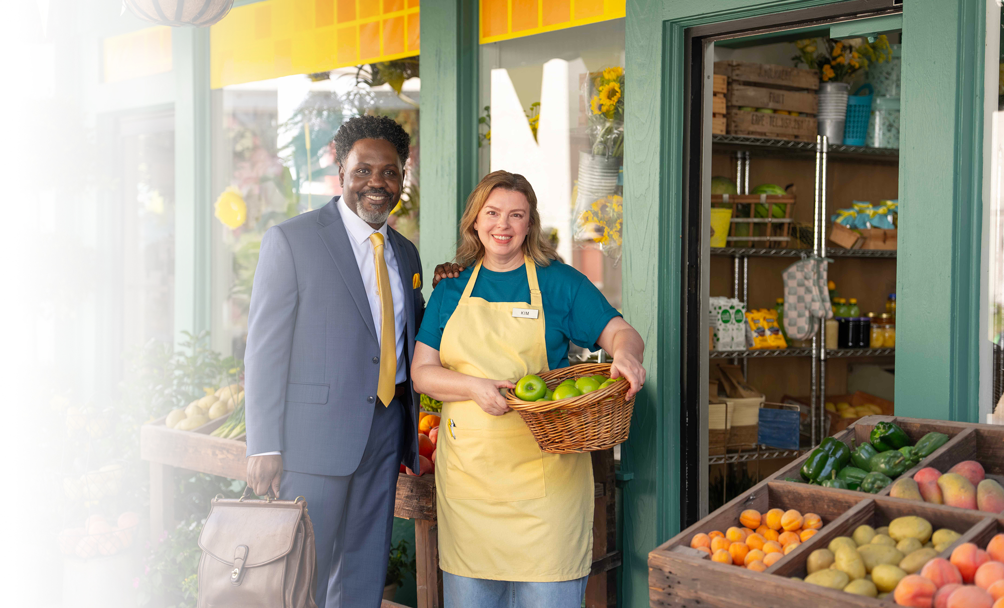 Businessman and vendor at farmers market holding fresh produce basket