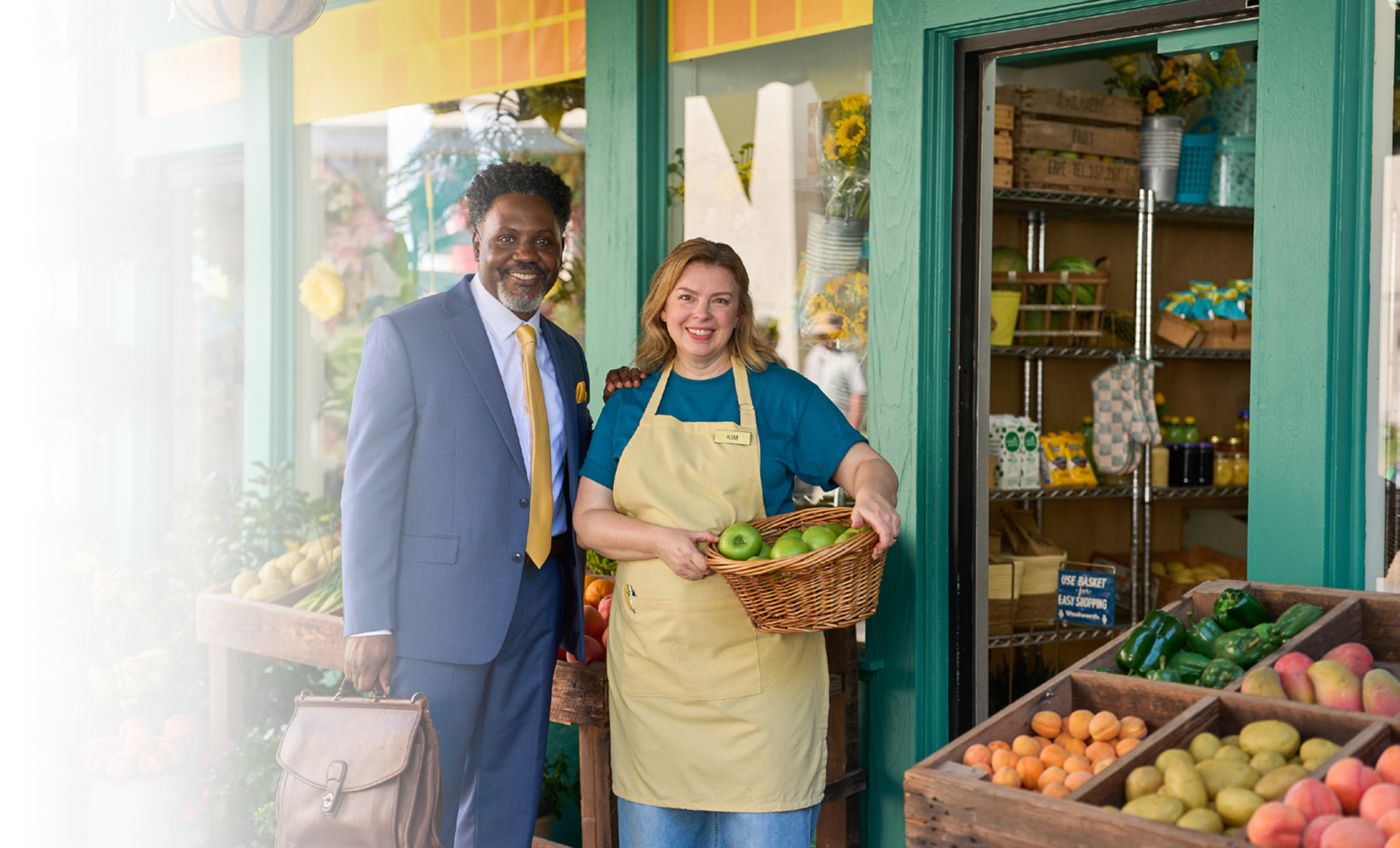 Businessman and vendor at farmers market holding fresh produce basket