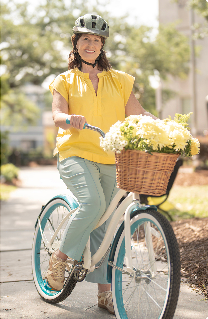 Woman on blue bicycle with flower basket